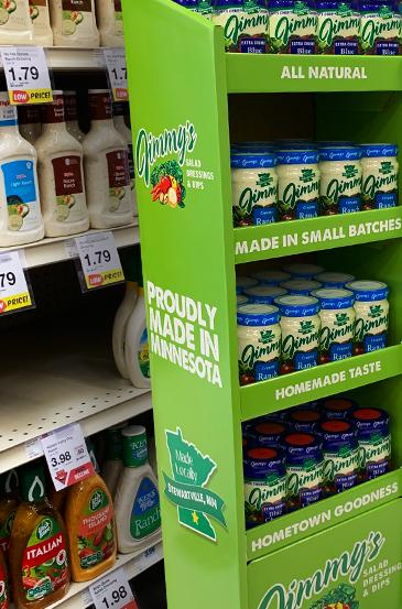 A green retail POP display containing Jimmy’s product jars