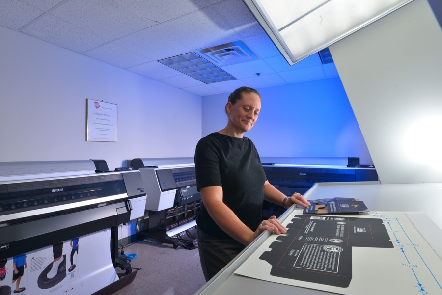 A CPG designer at BCI works with a digital print.