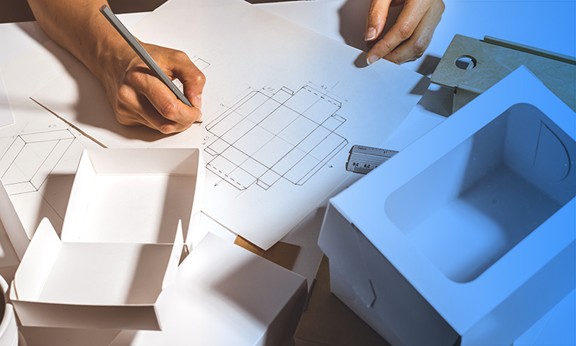 A designer works on rightsizing a custom-sized corrugated package. 