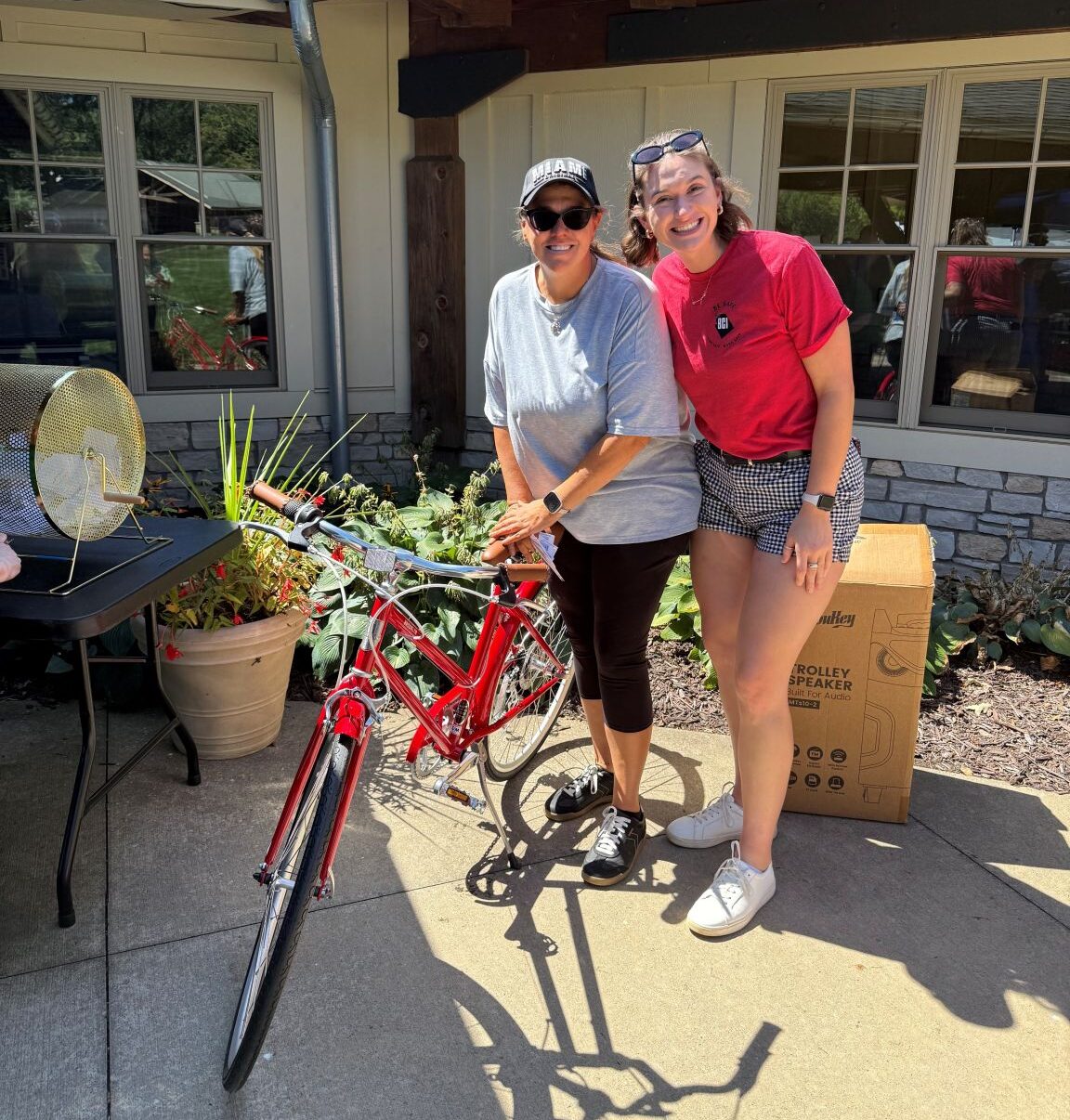 BCI Wooster’s Kelli Hacker with the bike donating it to an Akron Rotary Camp counselor